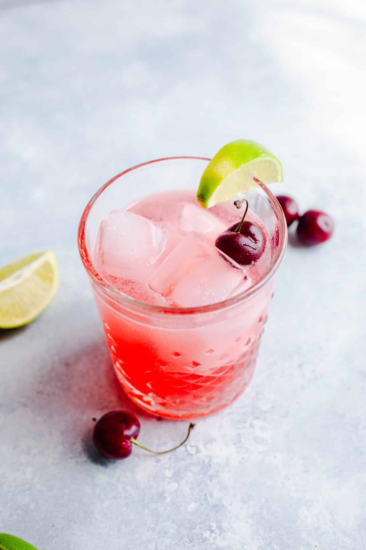 A cherry cocktail in a rocks glass.