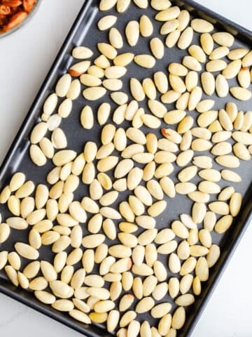 A sheet pan full of blanched almonds.