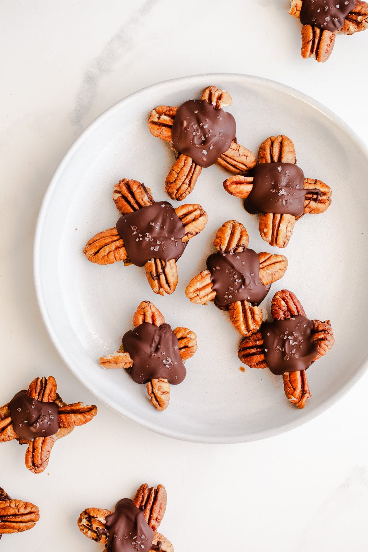 Chocolate pecan turtles on a plate. 