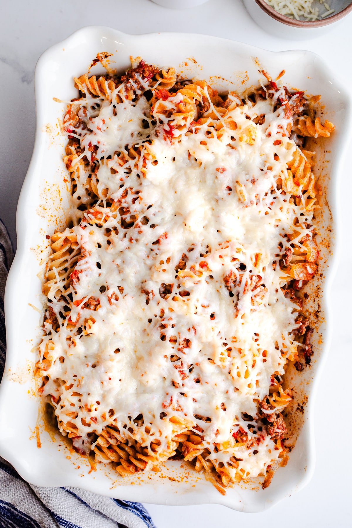 A casserole dish filled with pasta and topped with cheese.