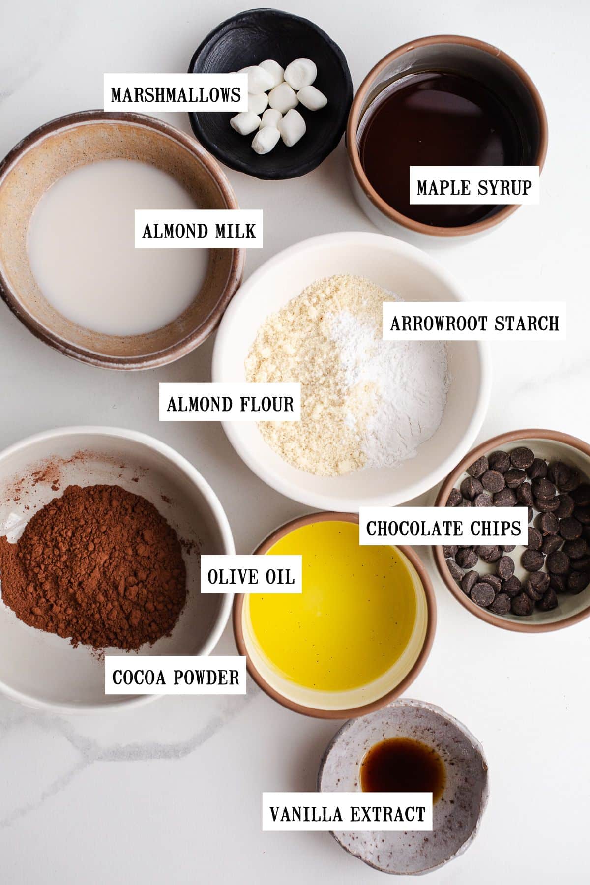 Ingredients to make hot cocoa mug cake in small bowls.