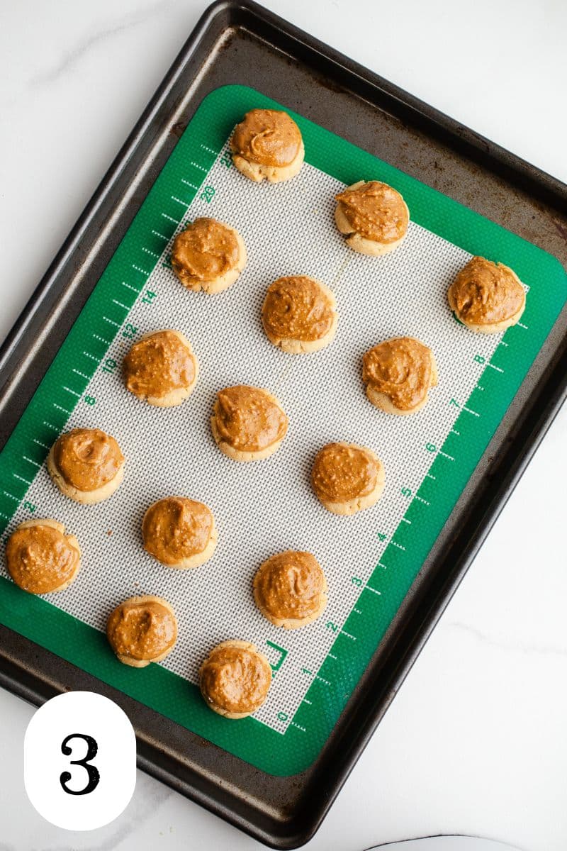 Peanut butter topped cookies on a tray.