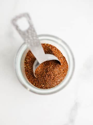 A glass jar filled with taco seasoning.