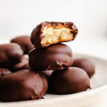 Chocolate covered cookies stacked on a plate.