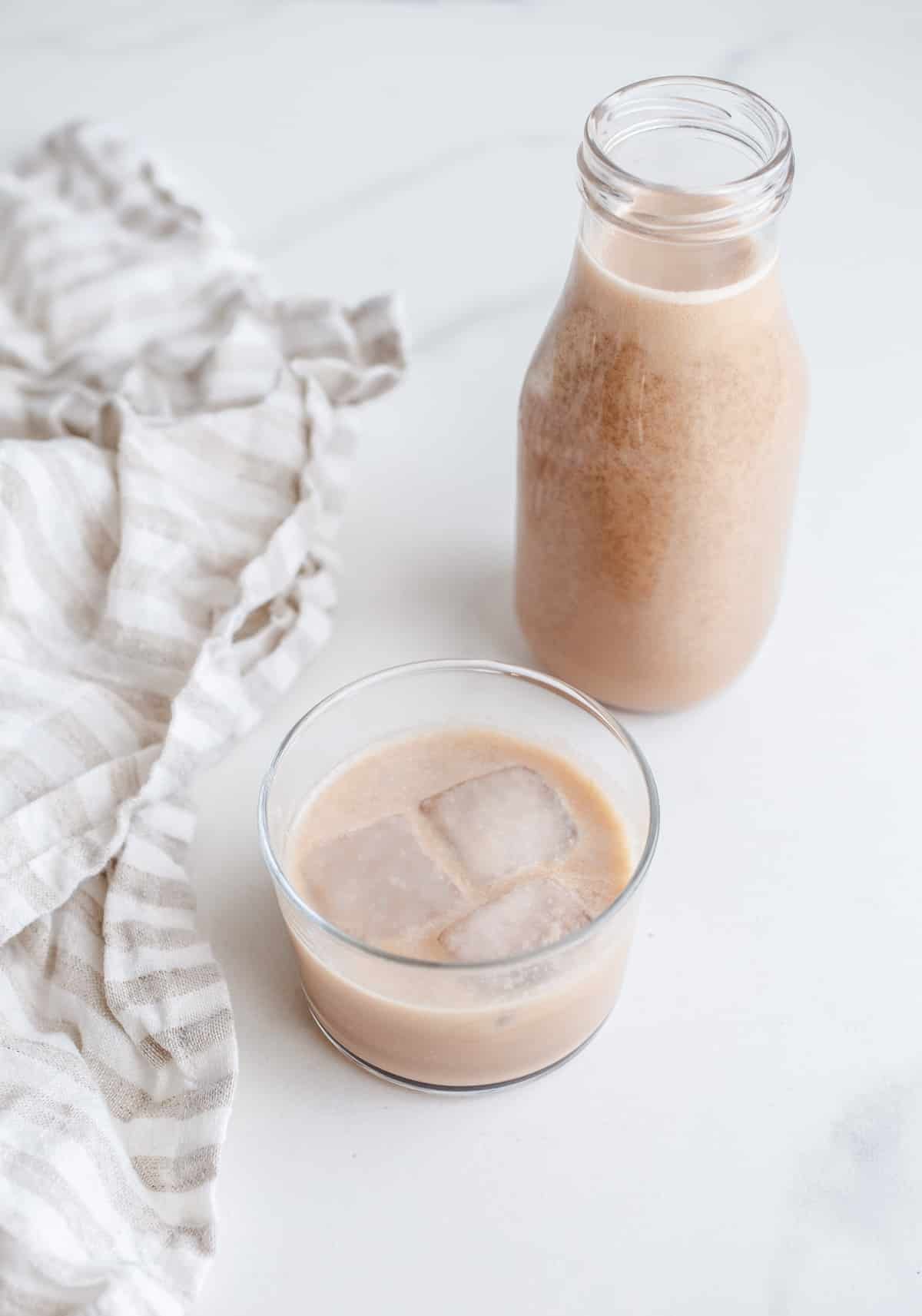 A bottle and glass filled with homemade Baileys.