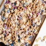 Chex mix with white chocolate on a sheet pan.