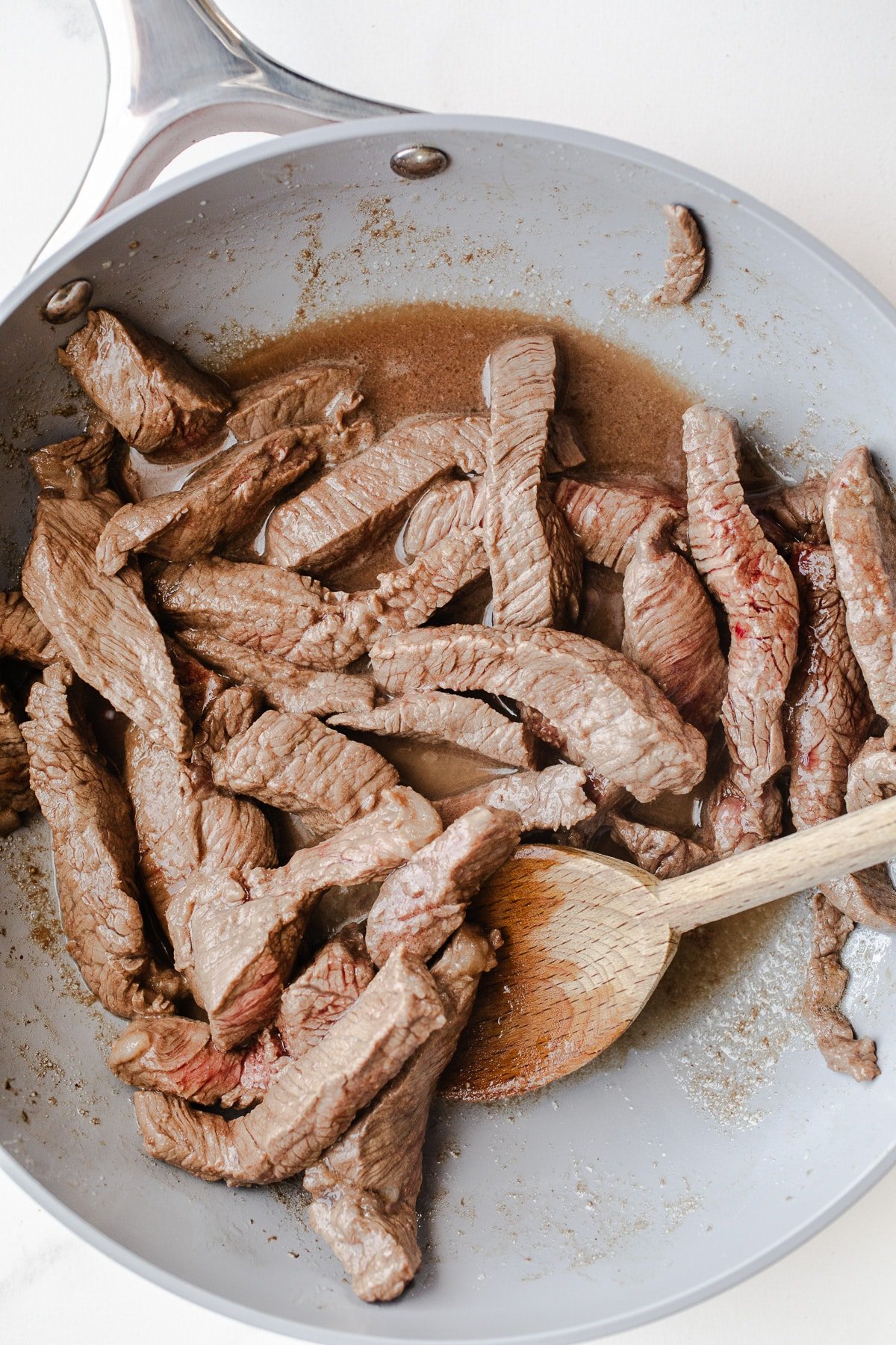 Strips of beef in a skillet.