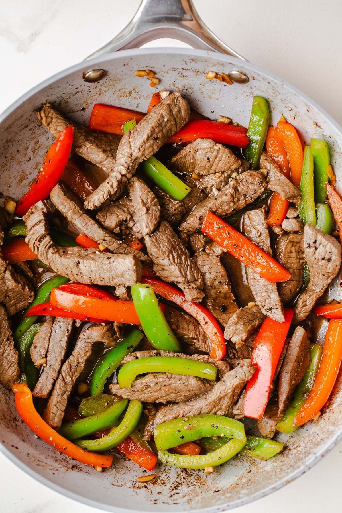 Beef and bell peppers in a skillet. 