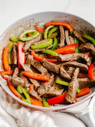 Beef and peppers in a skillet.
