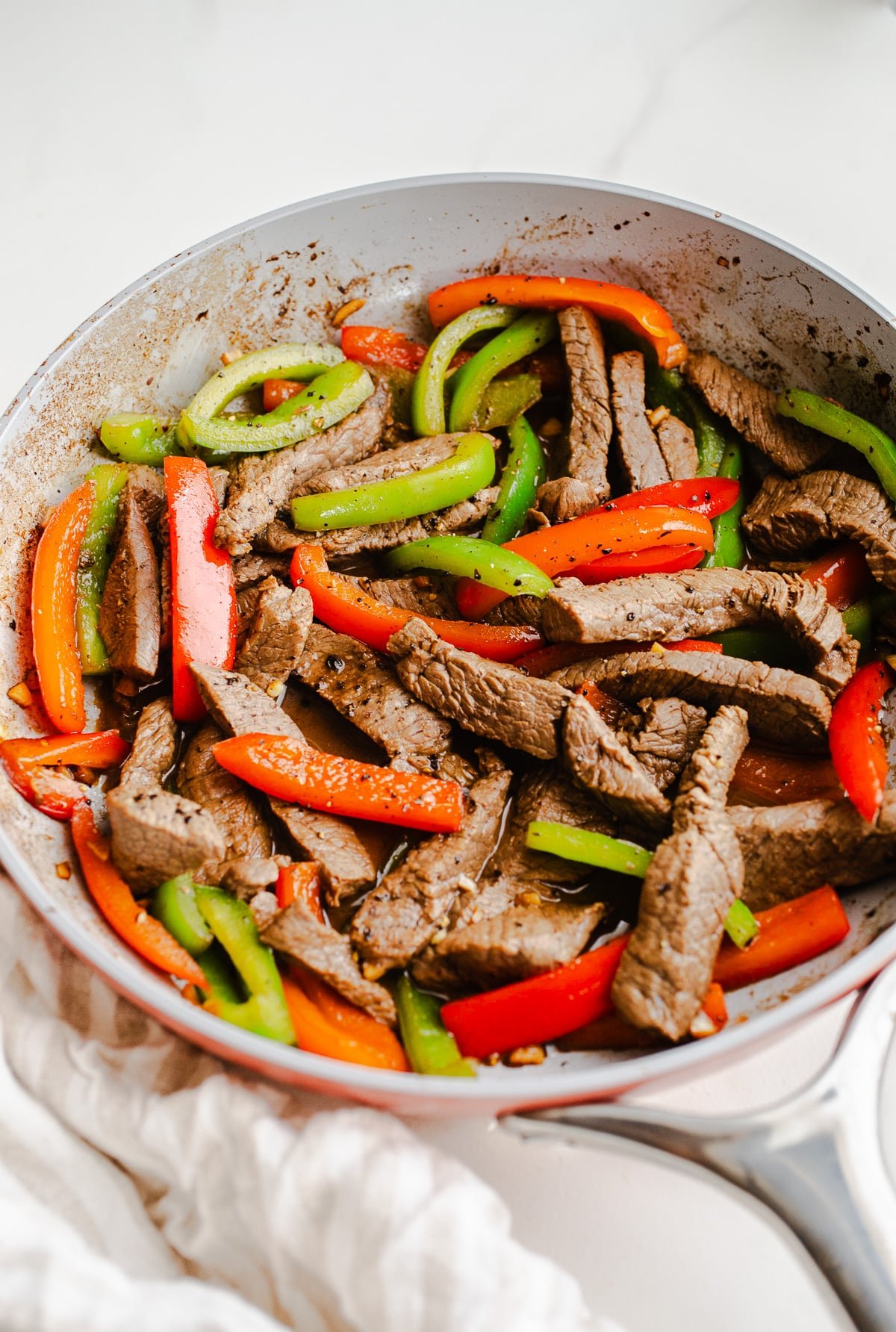 Beef and peppers in a skillet.