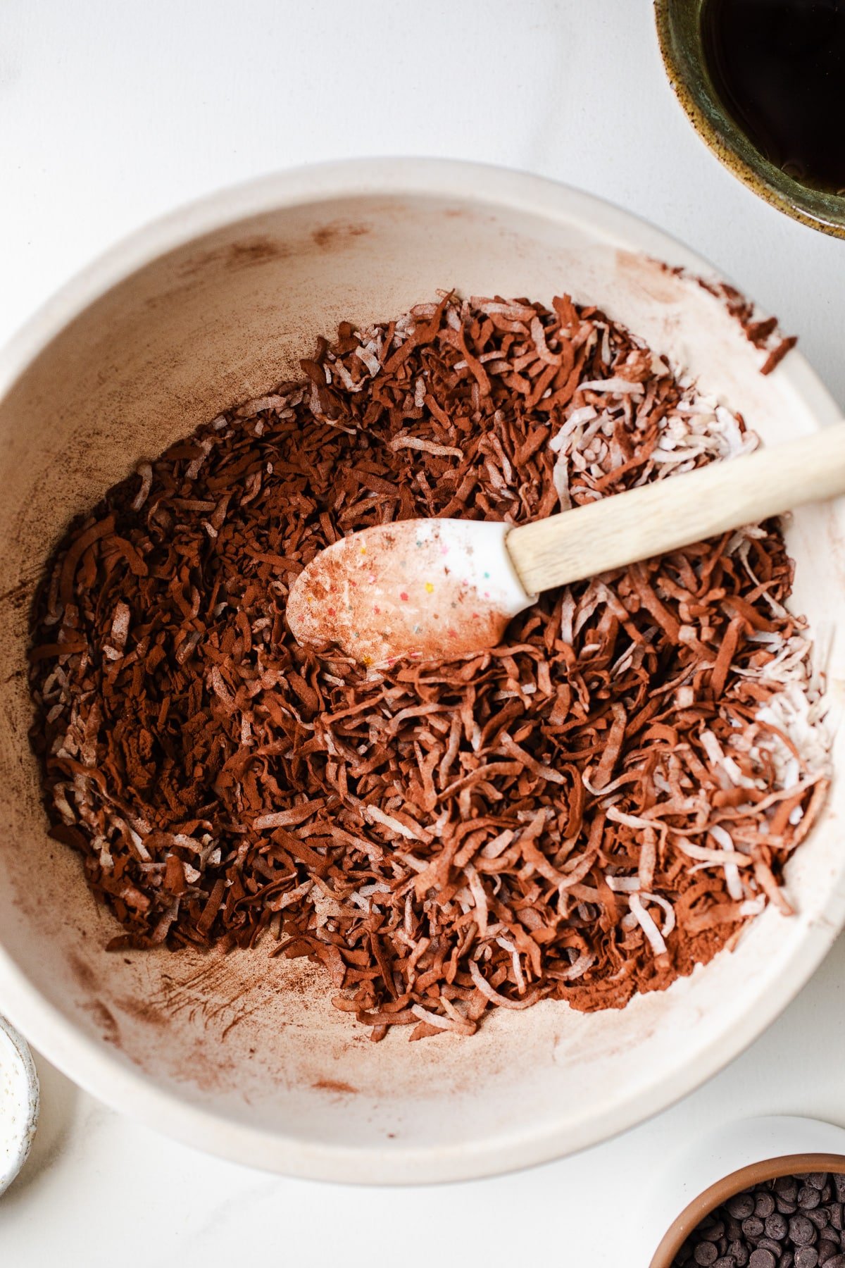 Shredded coconut and cocoa powder in a mixing bowl.