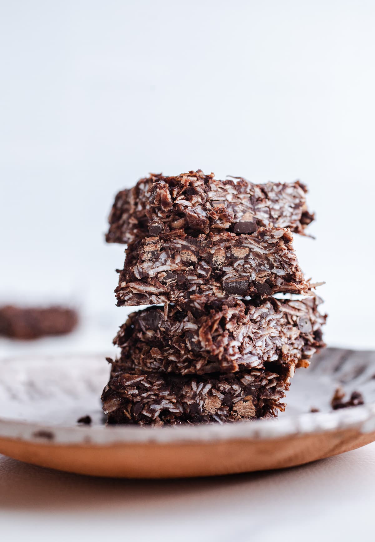 A stack of chocolate coconut bars on a plate.