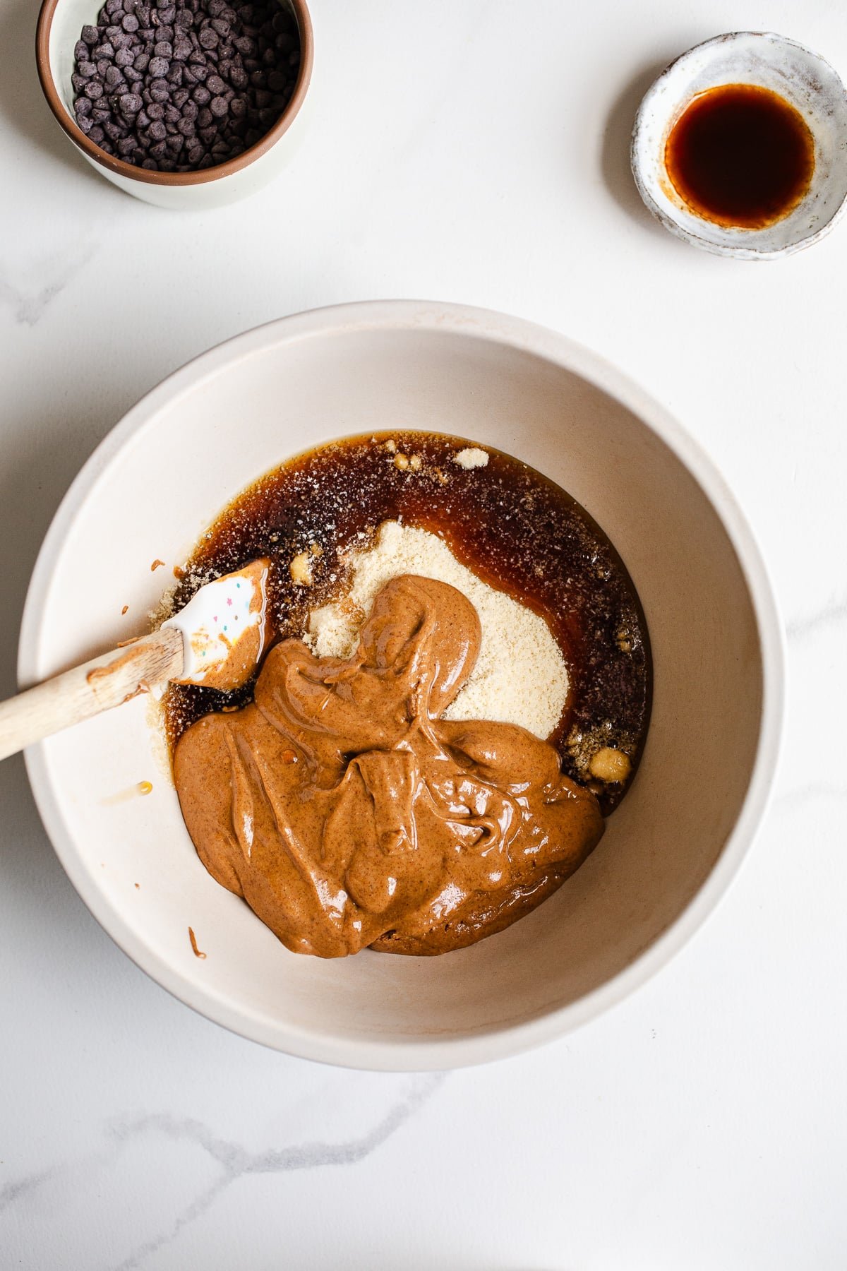 A mixing bowl with almond butter and maple syrup.