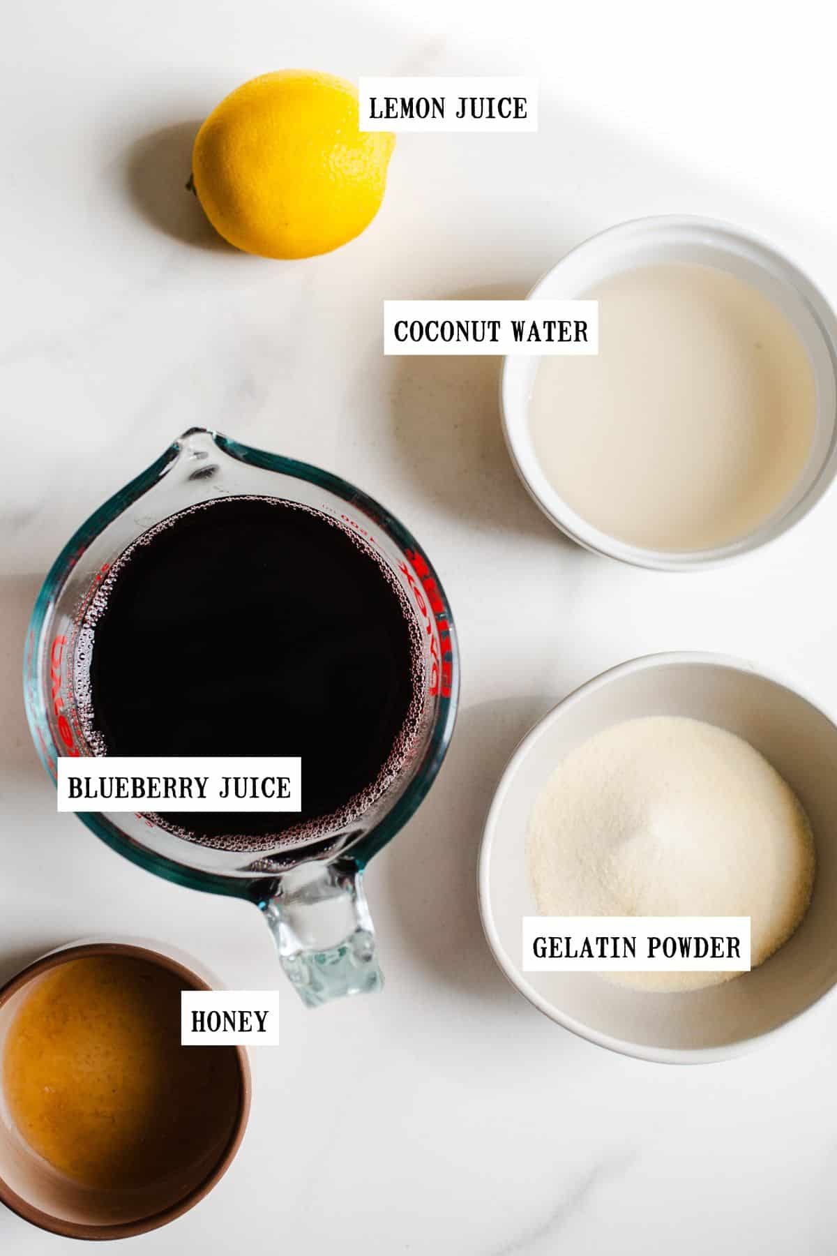 Ingredients to make blueberry gummies in small bowls.