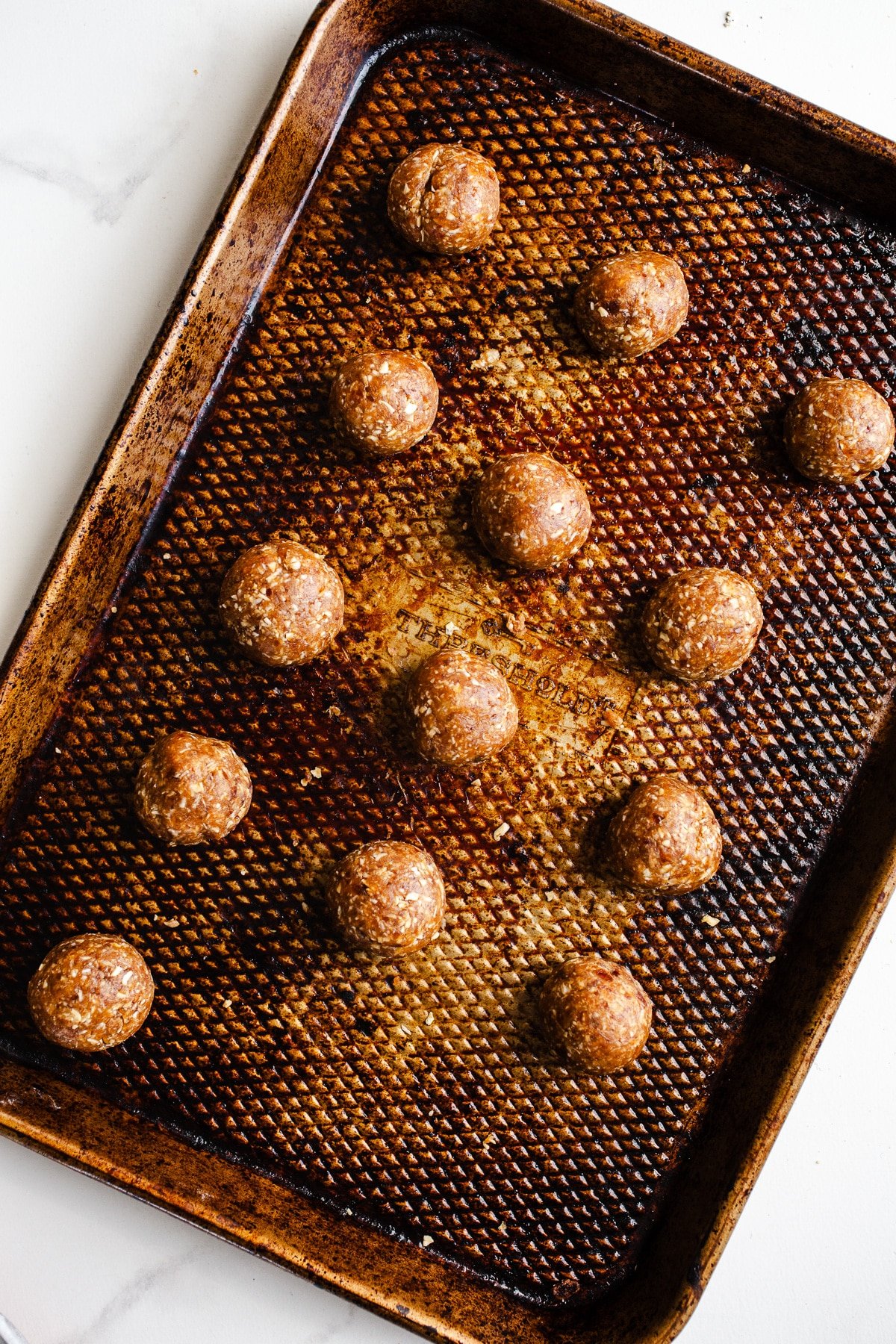 Salted caramel bliss balls on a baking sheet.