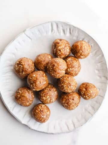 Date energy balls on a white plate.