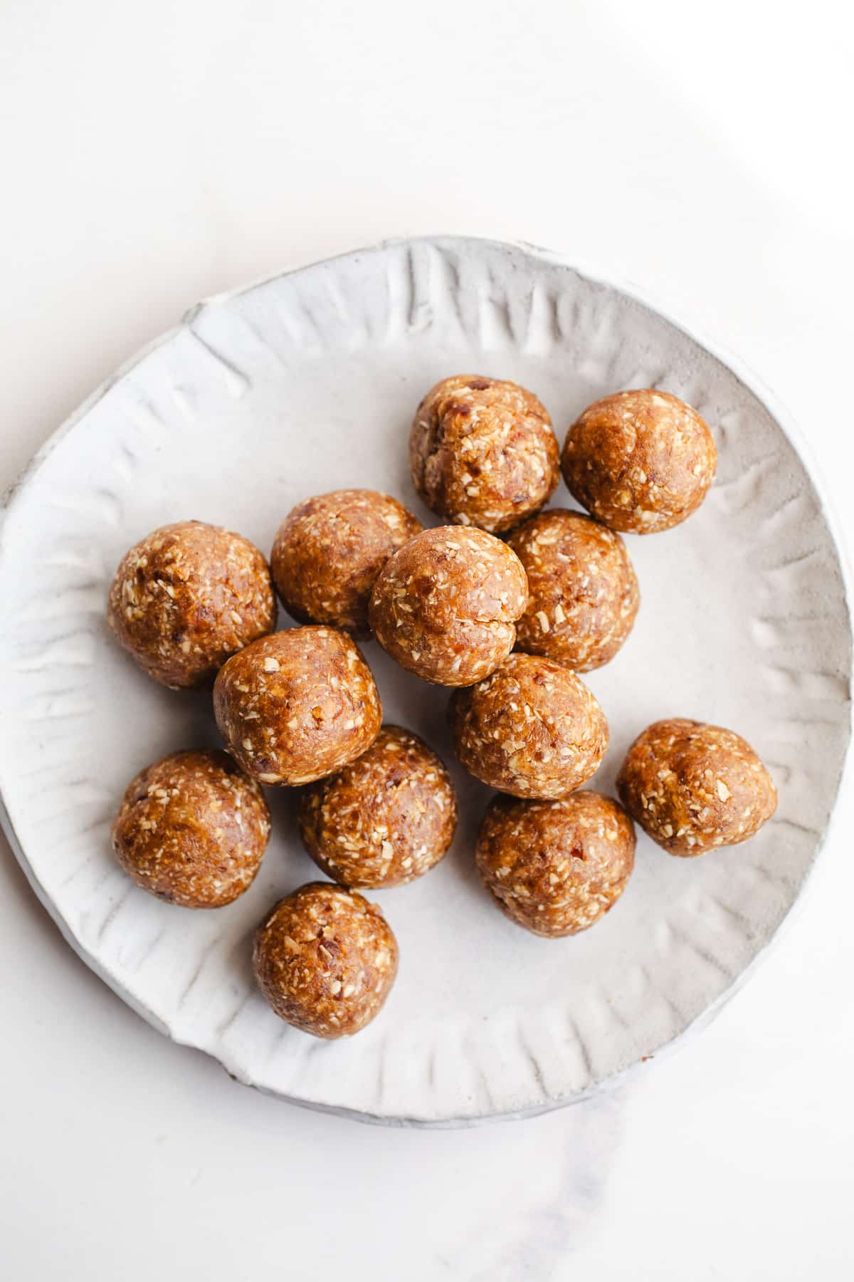 Date energy balls on a white plate.