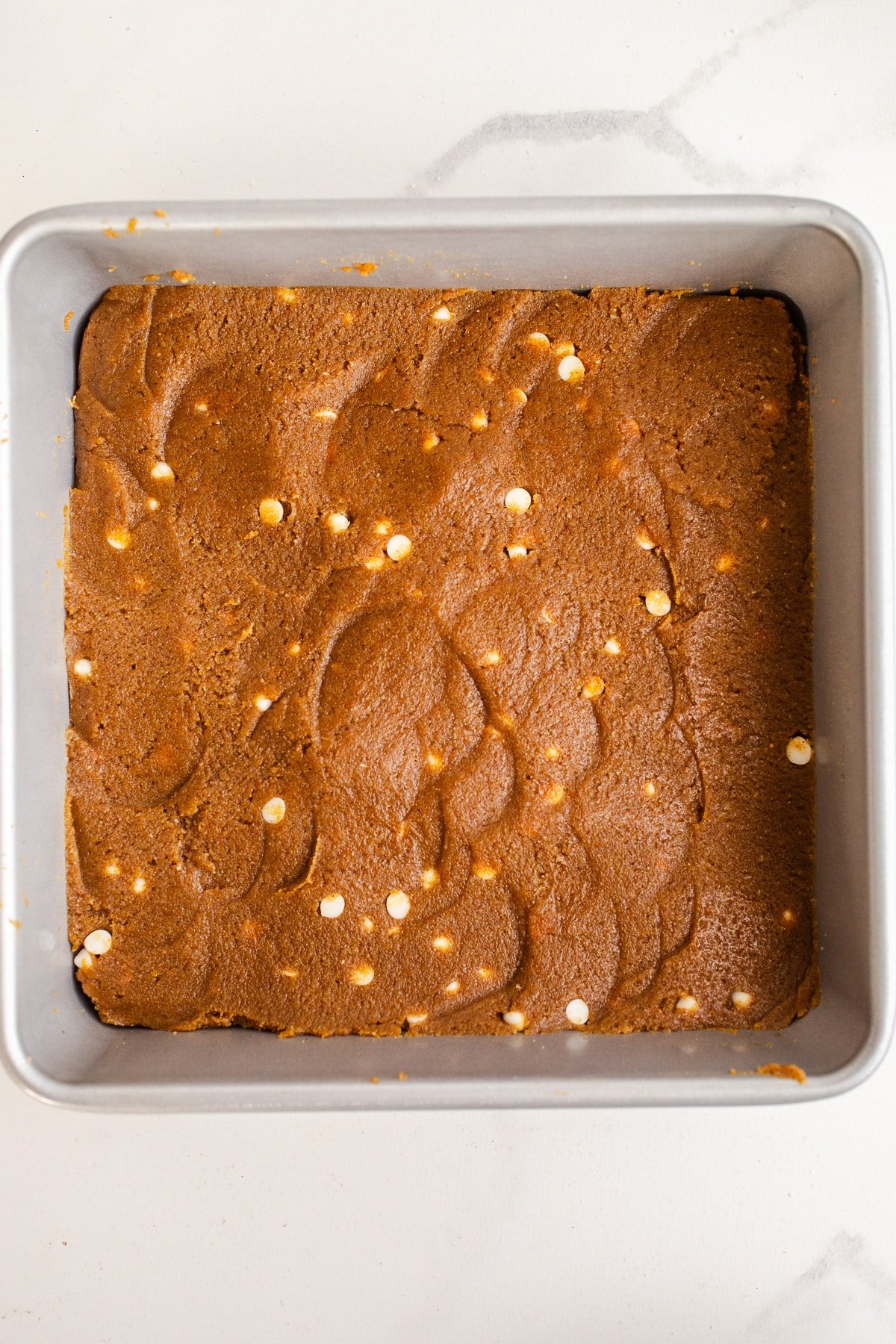 Pumpkin protein dough in a square pan.