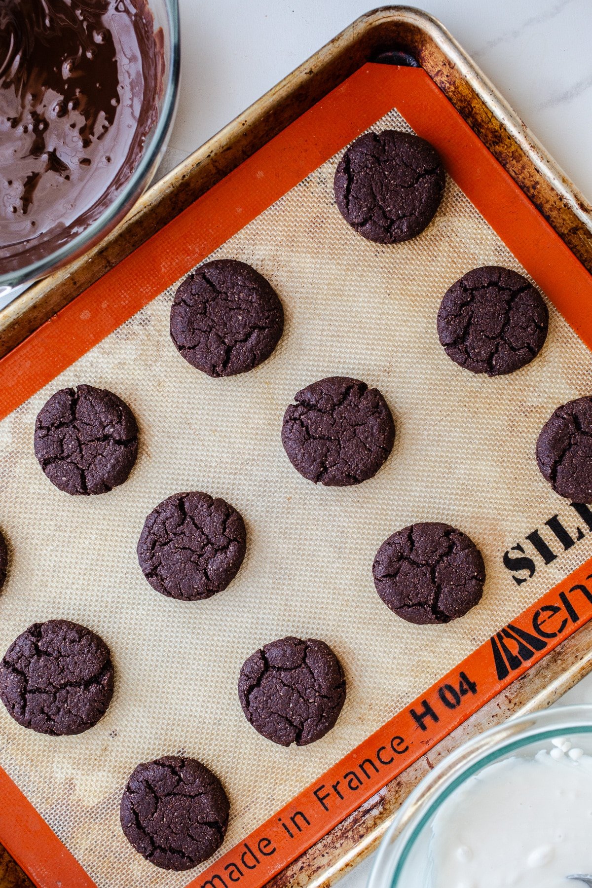 Baked chocolate cookies on a baking sheet.