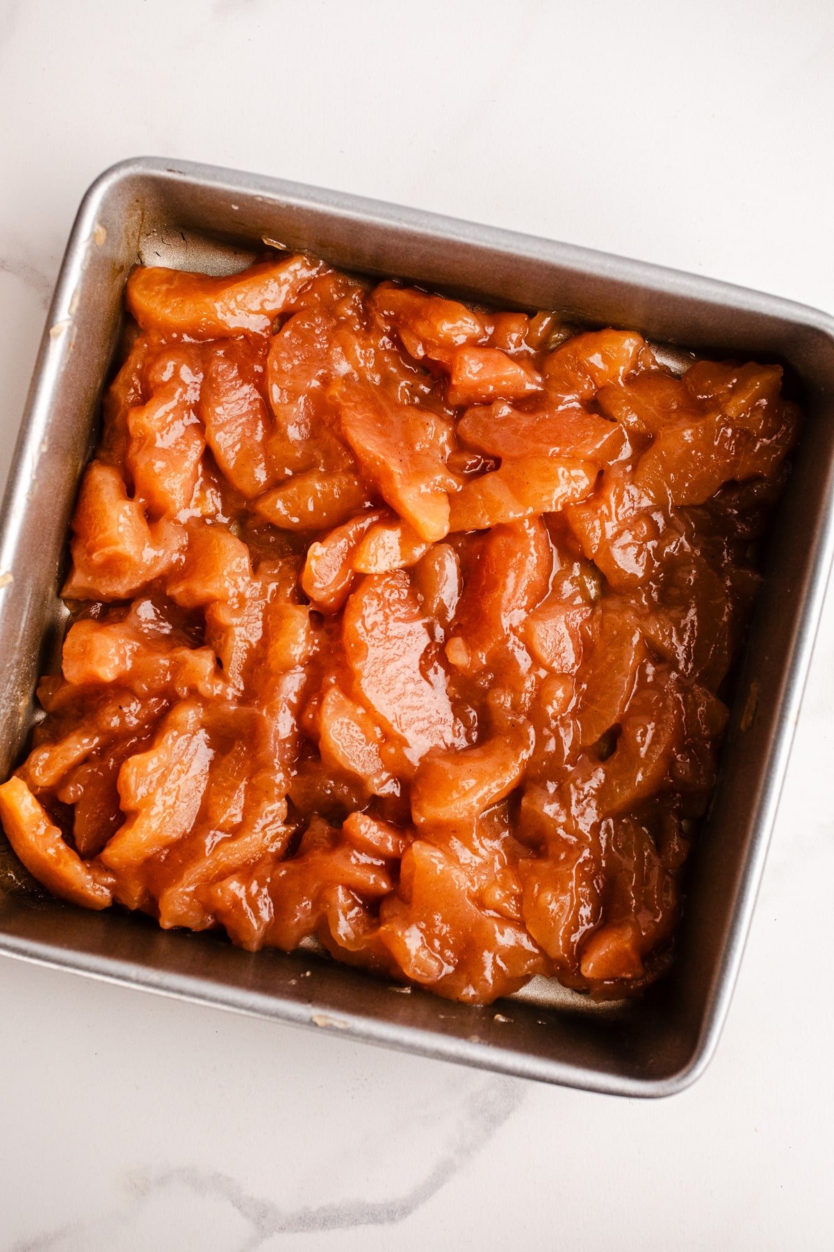 Spiced apples in a baking pan.