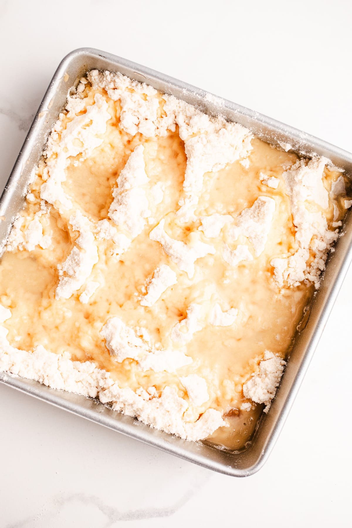 Melted coconut oil on top of cake mix in a pan.