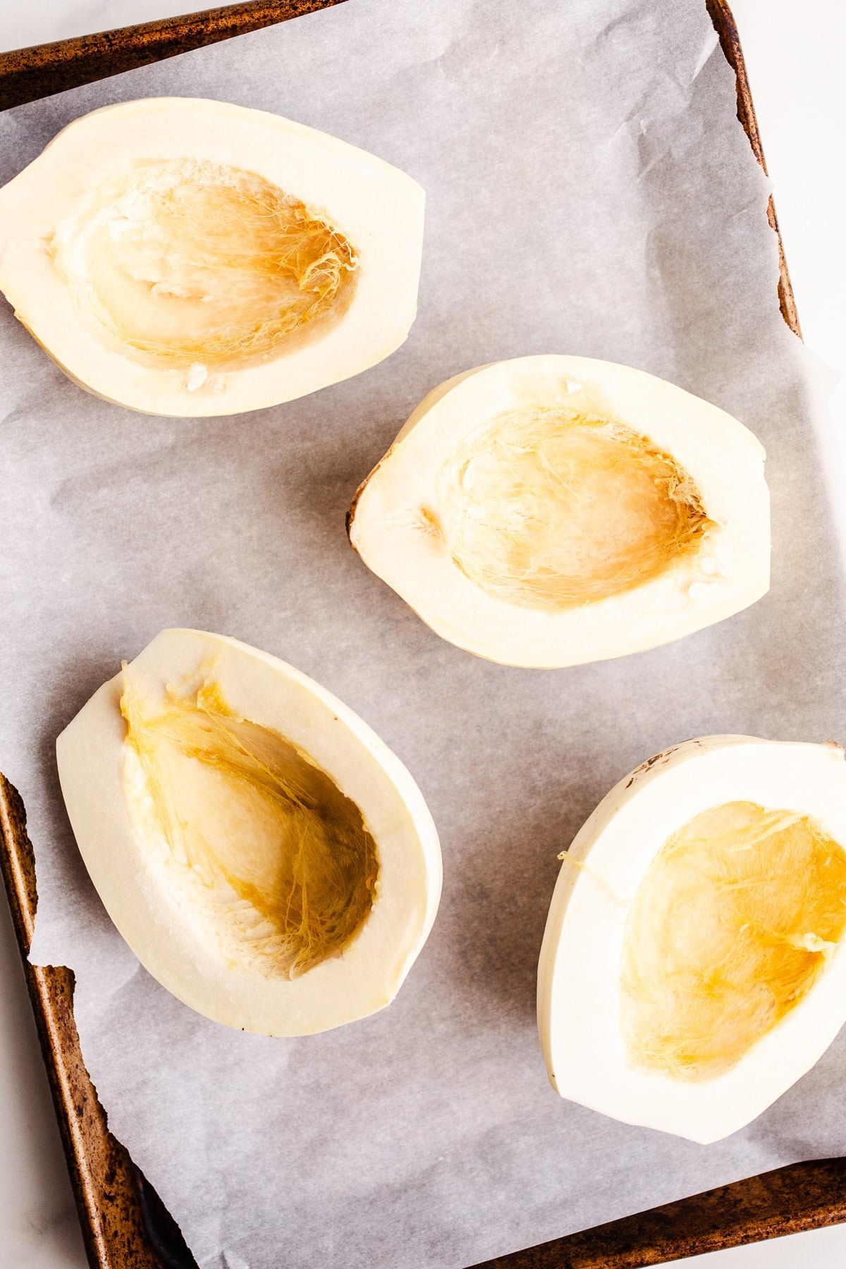 Squash halves on a baking sheet.