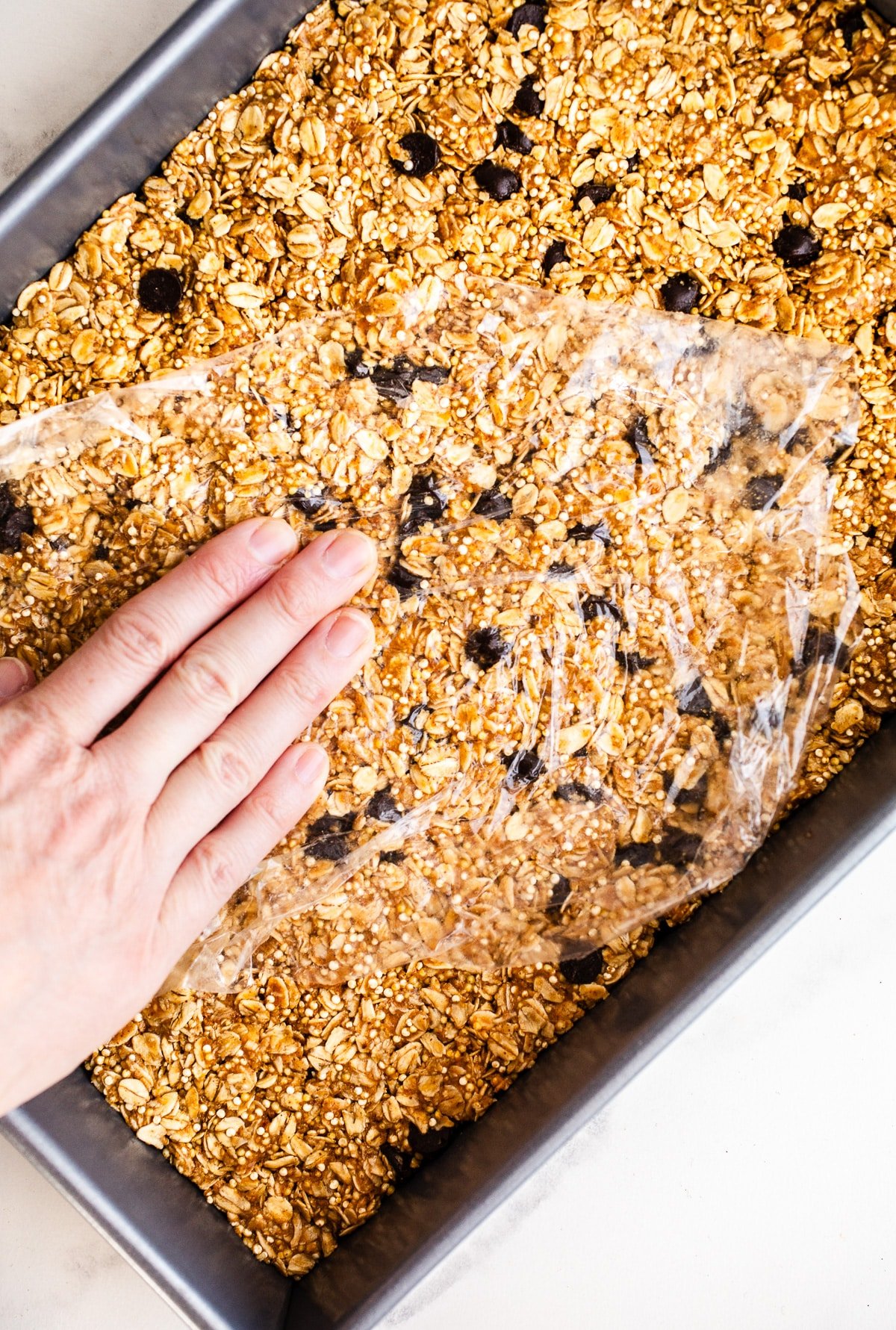 Oat mixture pressed into a baking pan.