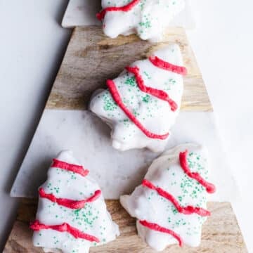 White chocolate Christmas tree cakes on a marbled platter.