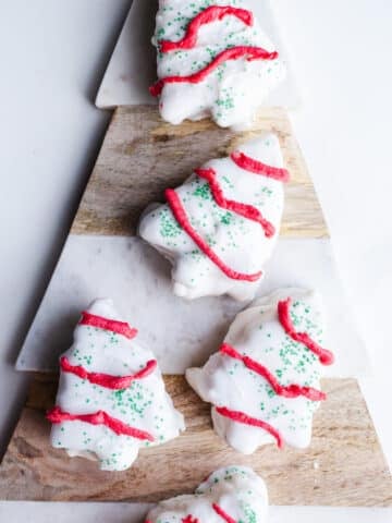White chocolate Christmas tree cakes on a marbled platter.