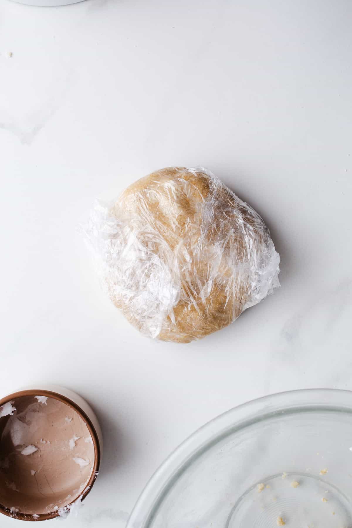 Pie dough wrapped in plastic wrap.
