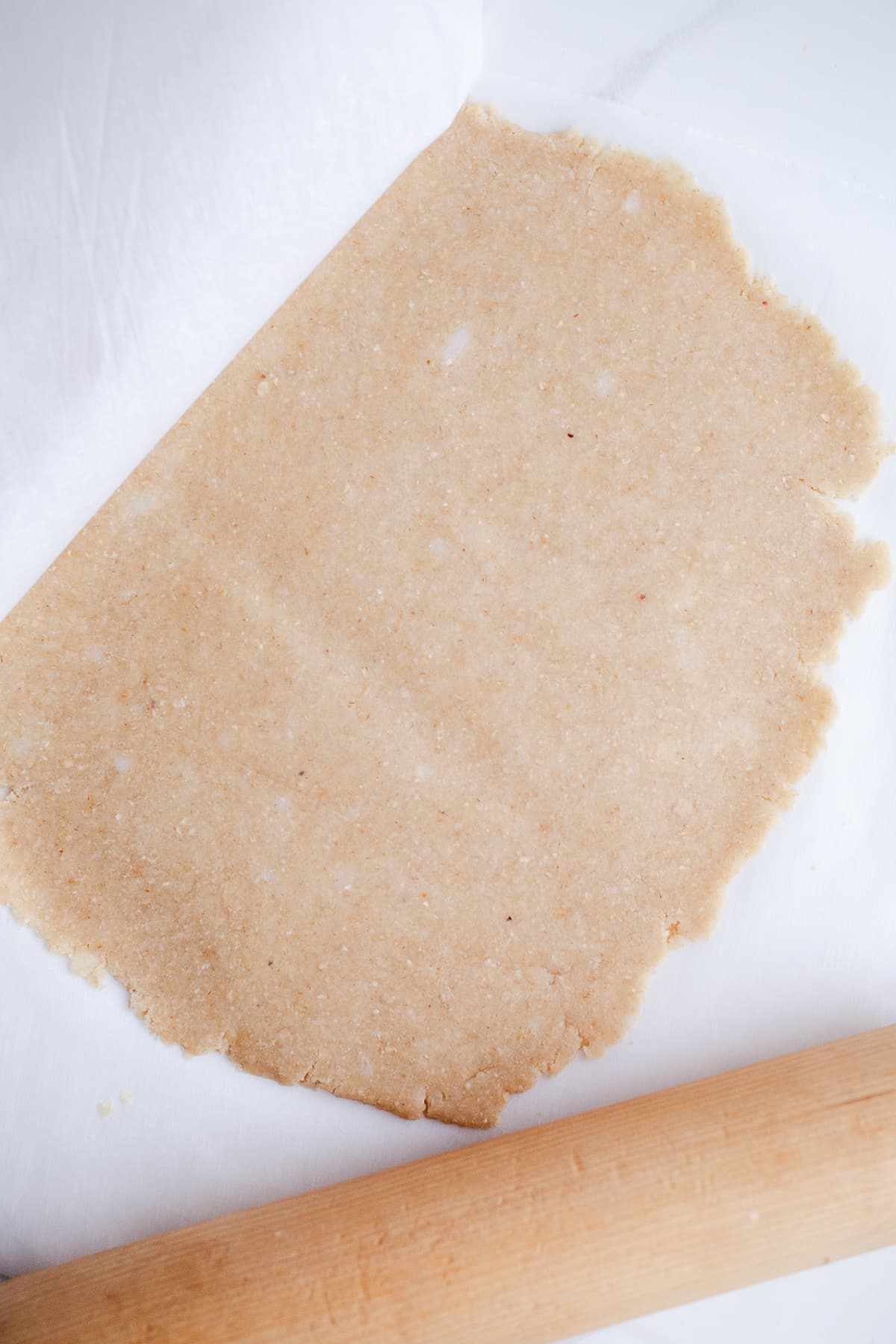 Rolled out pie dough on parchment paper.