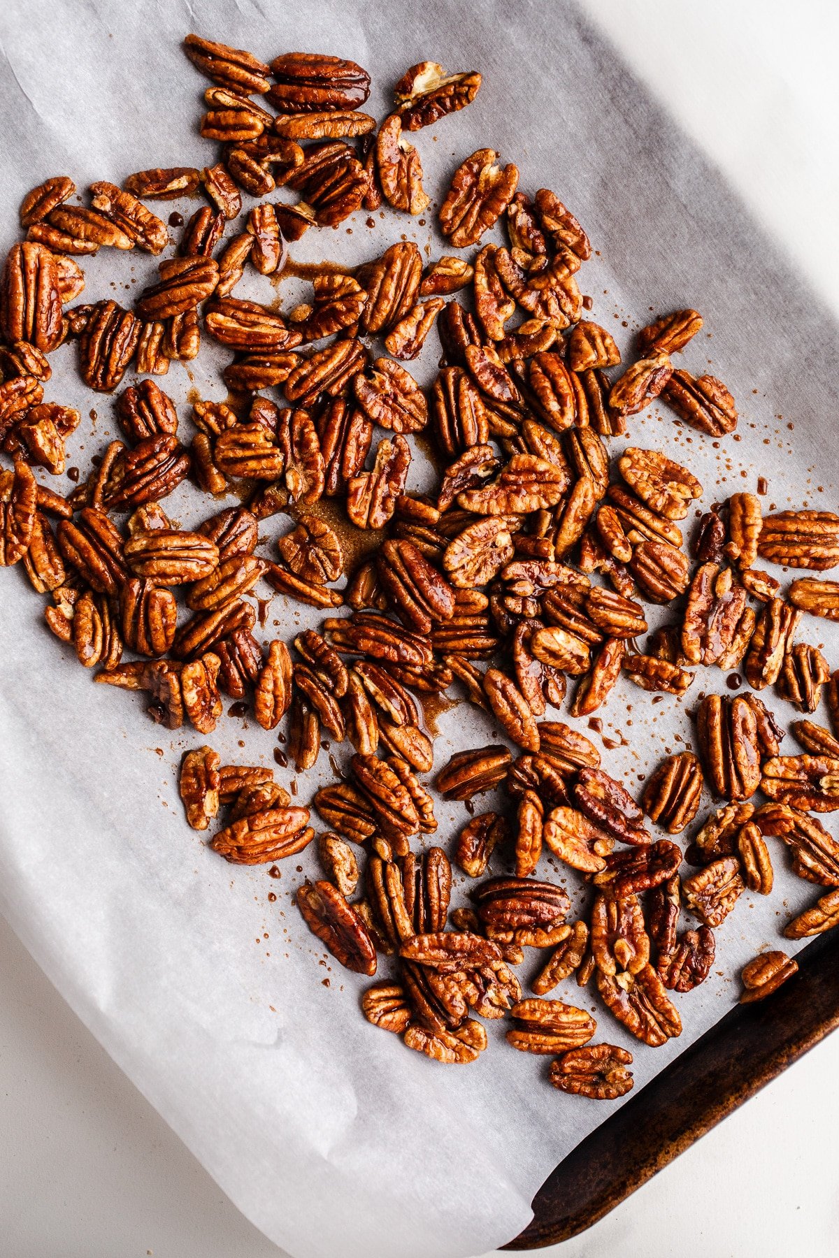 Pecans spread out on a baking sheet.
