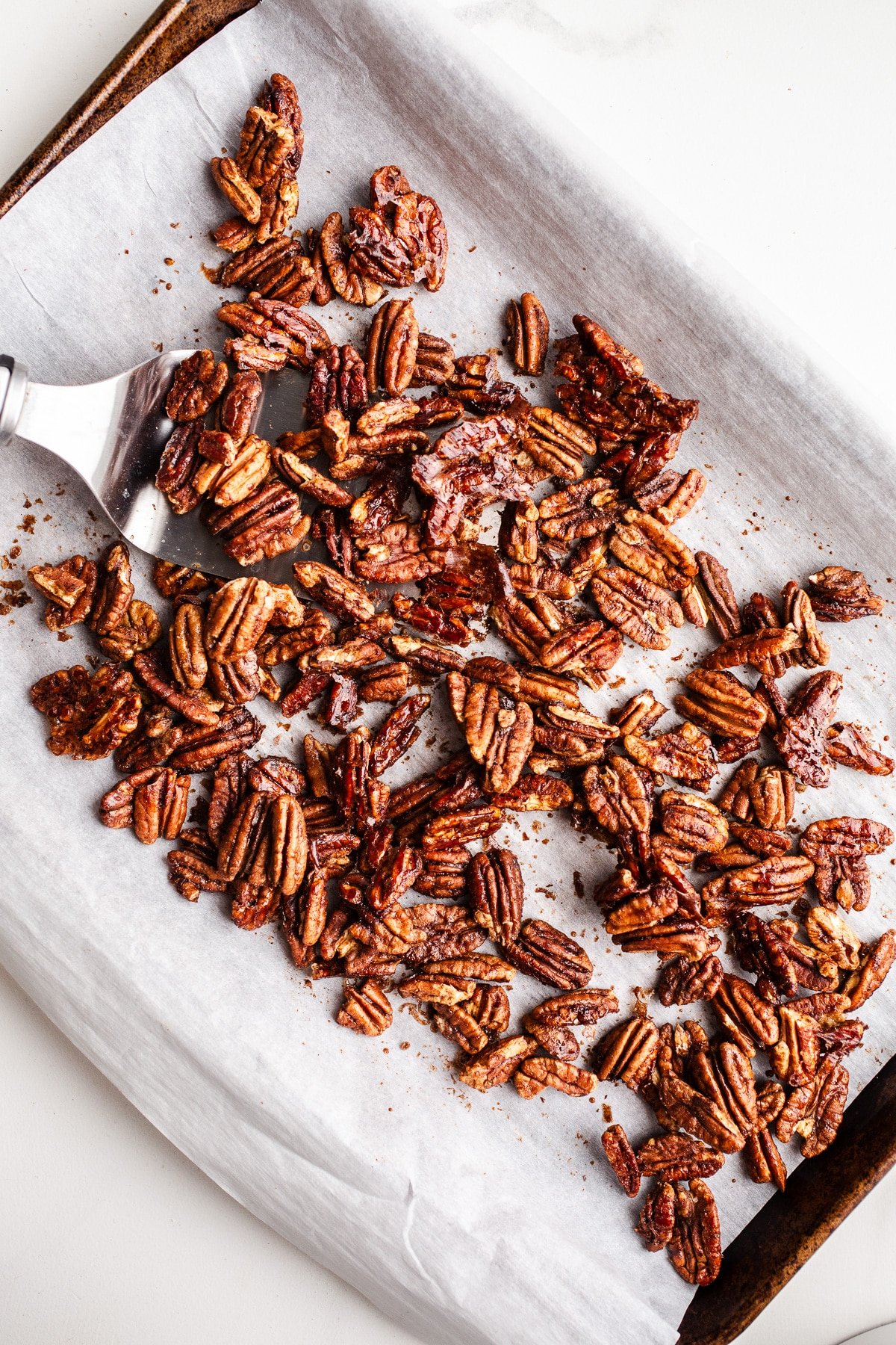 Baked pecans on a baking sheet.