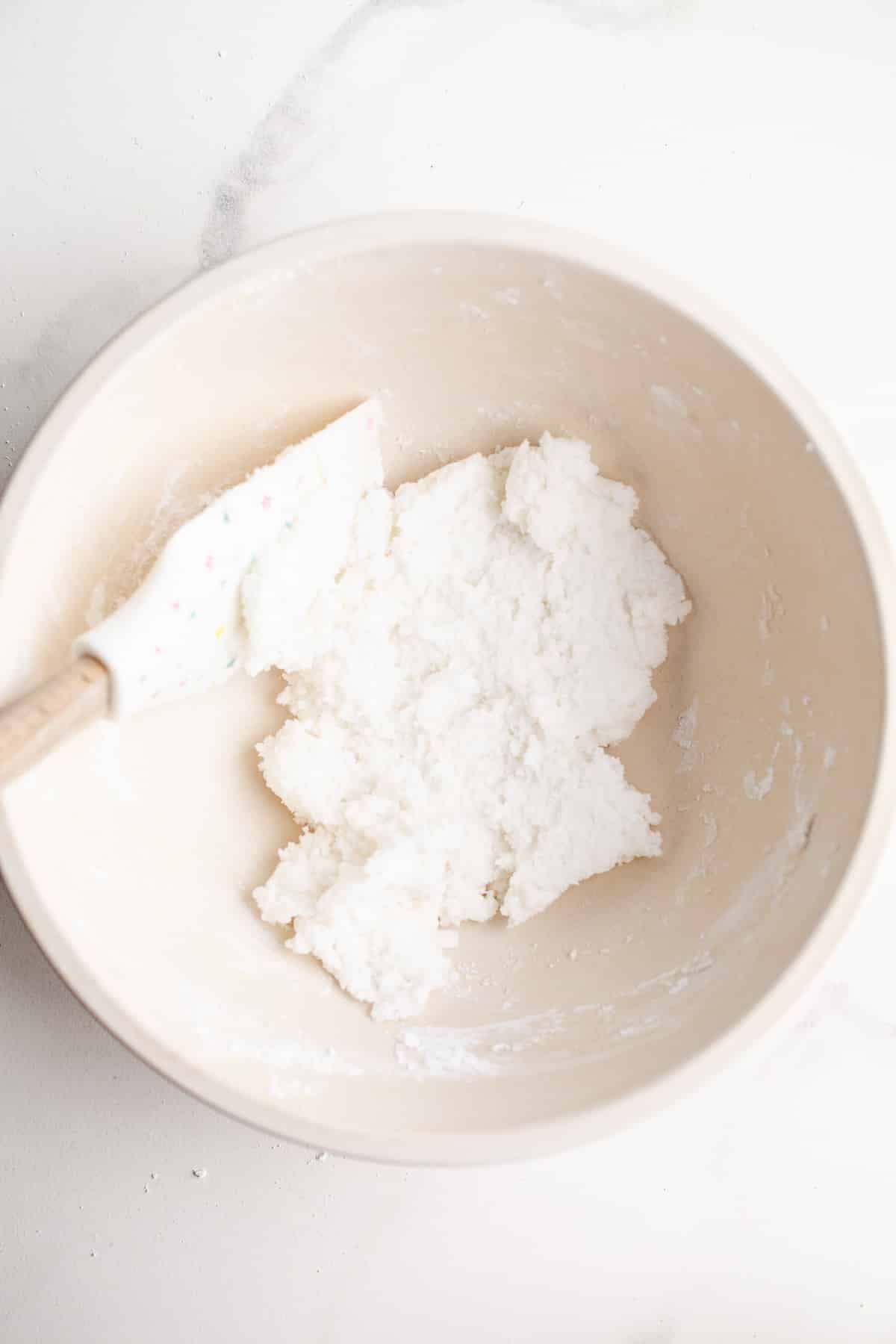Powdered sugar and coconut oil in a mixing bowl.