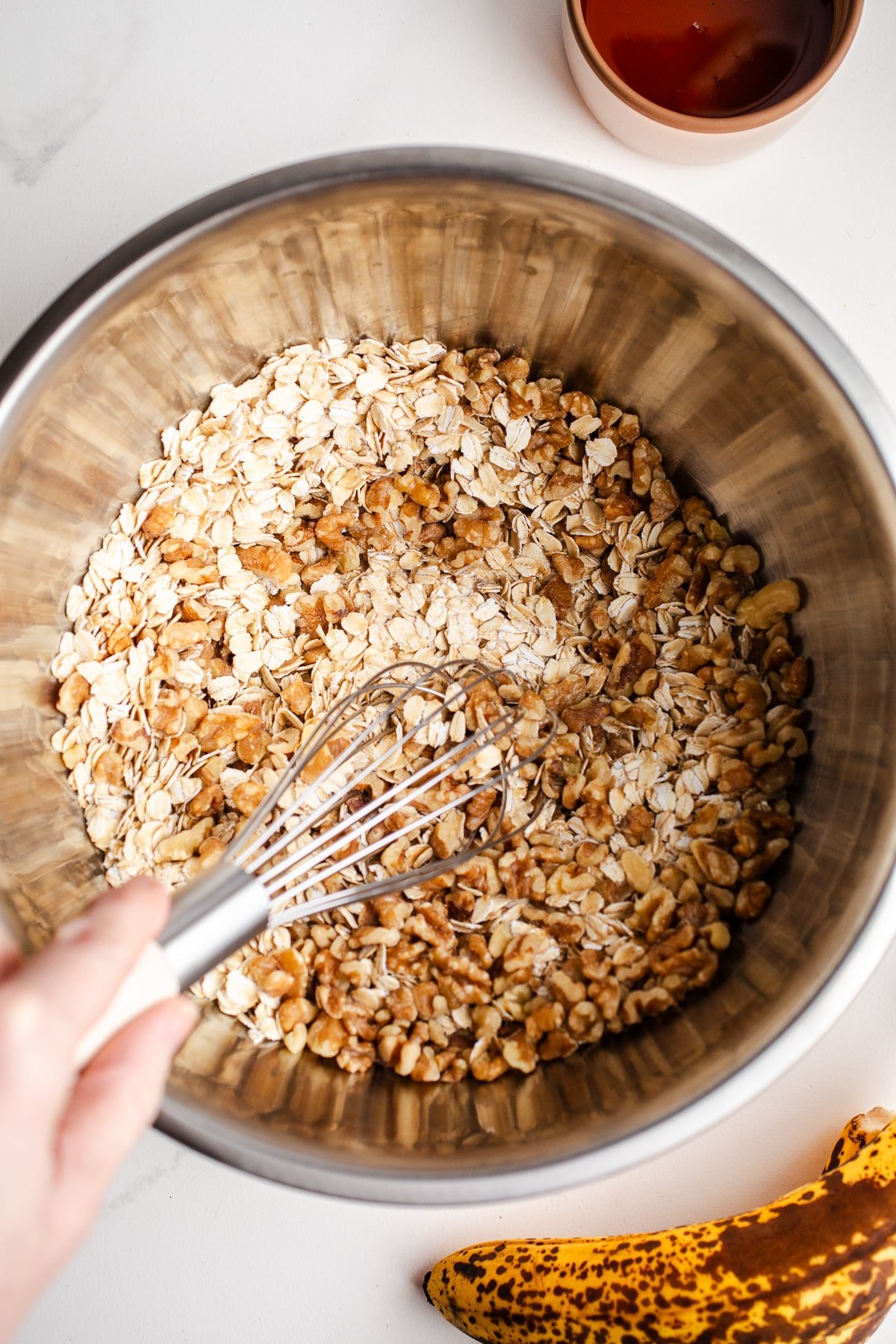 Oats and walnuts in a mixing bowl. 