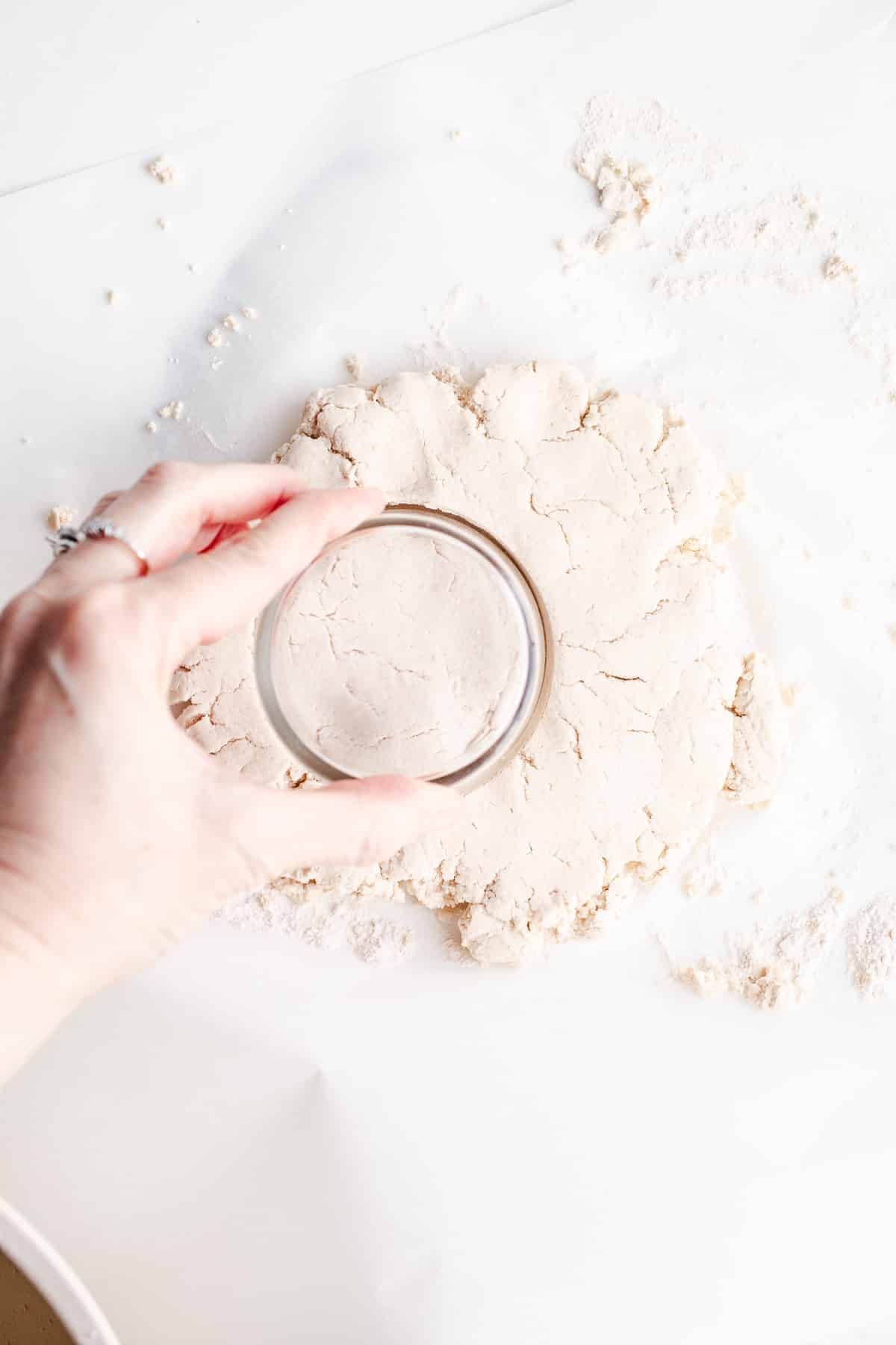 Cutting biscuit dough on parchment paper.