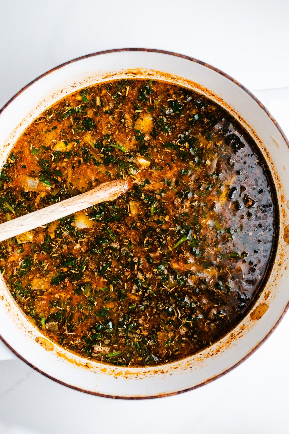 Seasoning stirred into broth in a pot. 