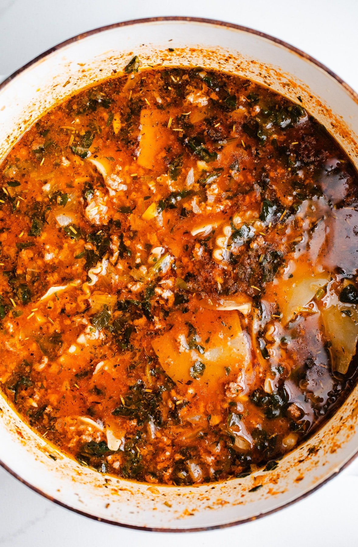 Lasagna soup in a large white pot.