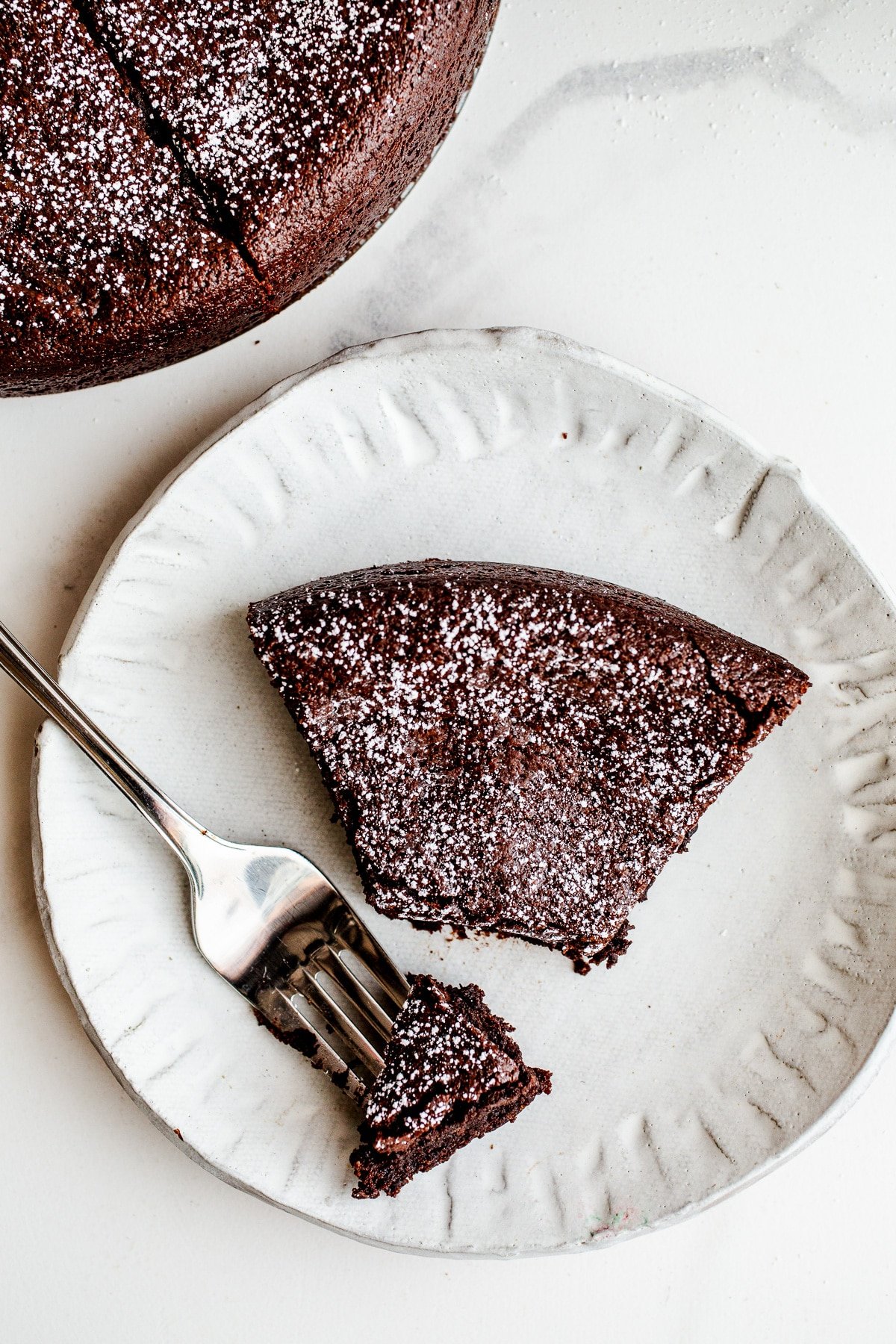 A slice of chocolate cake on a white plate.