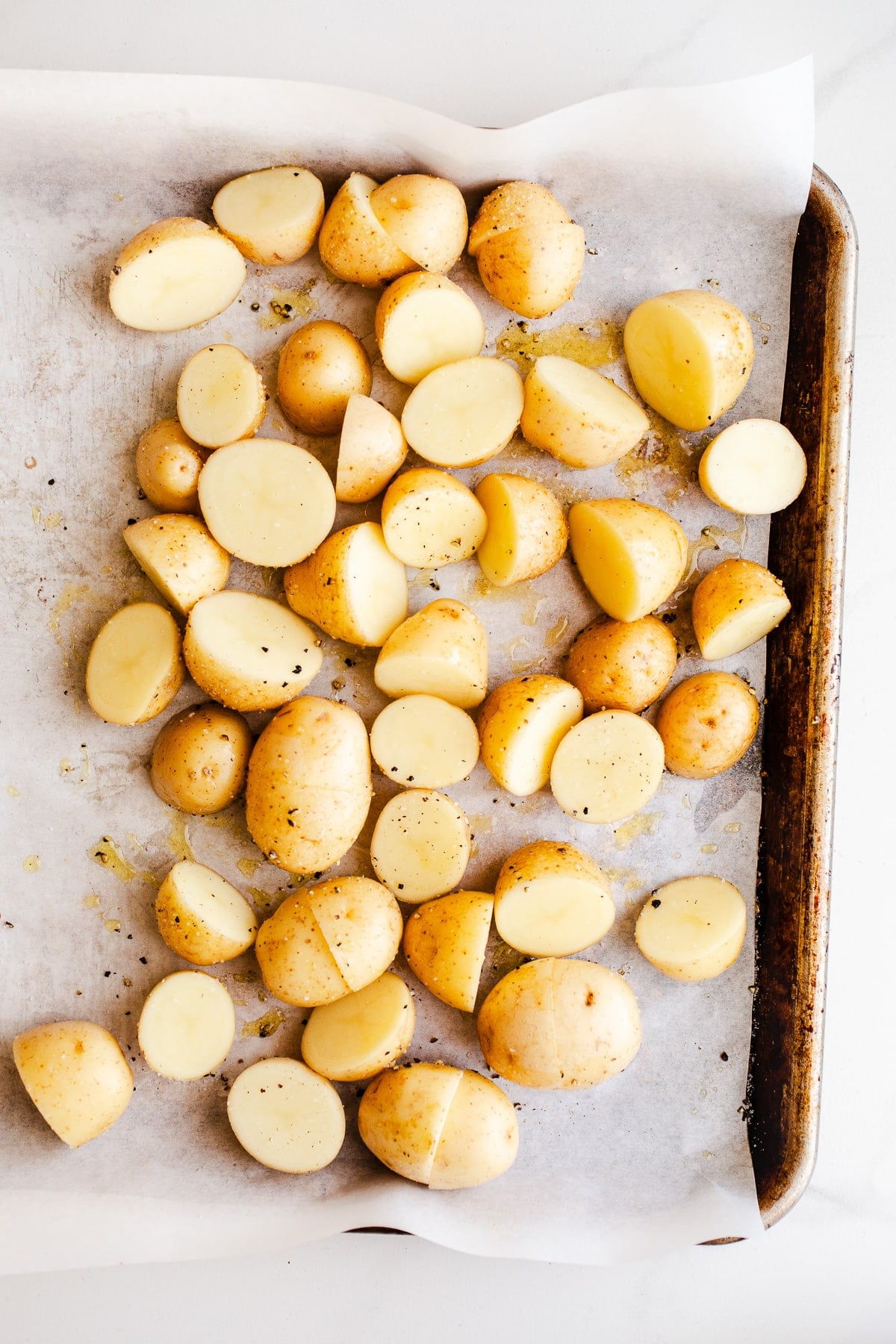 Raw baby potatoes on a sheet pan.