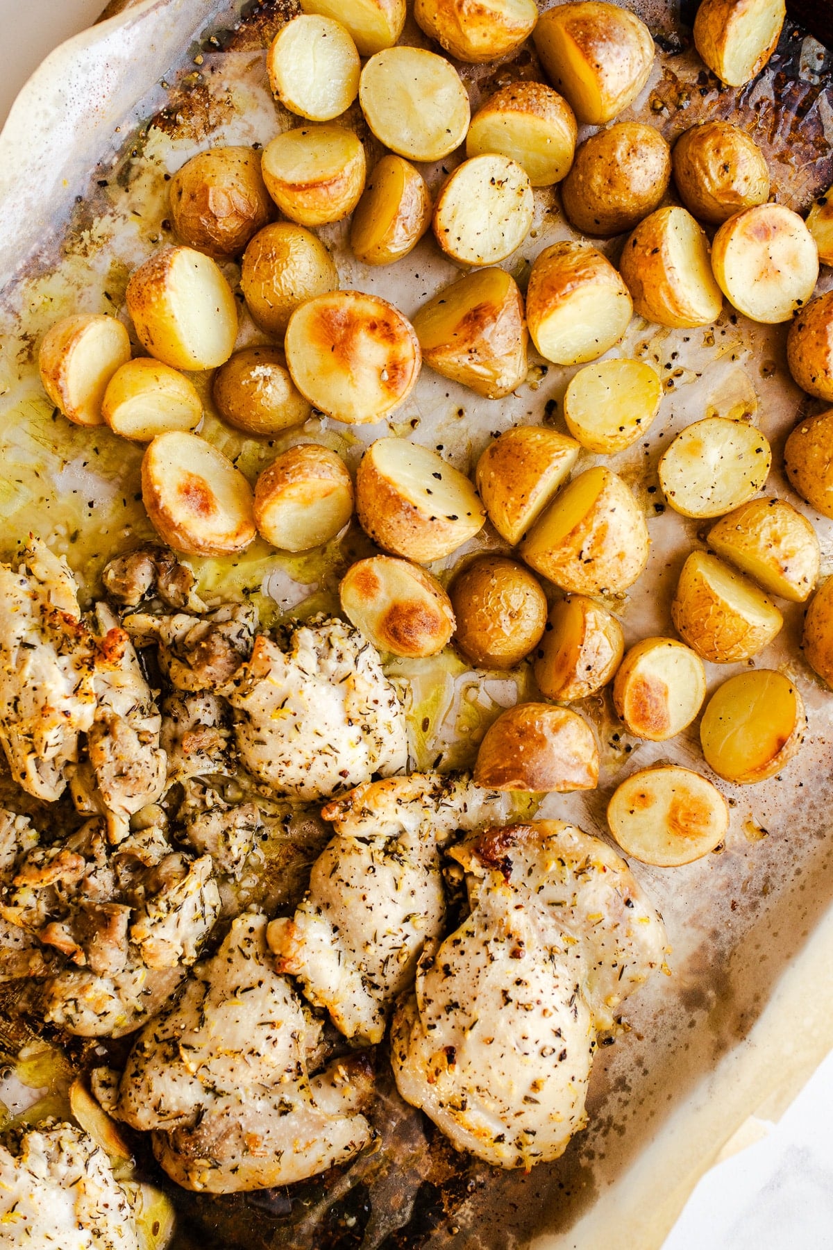 Baked chicken and potatoes on a sheet pan. 