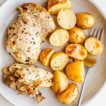 Chicken thighs and potatoes on a plate.