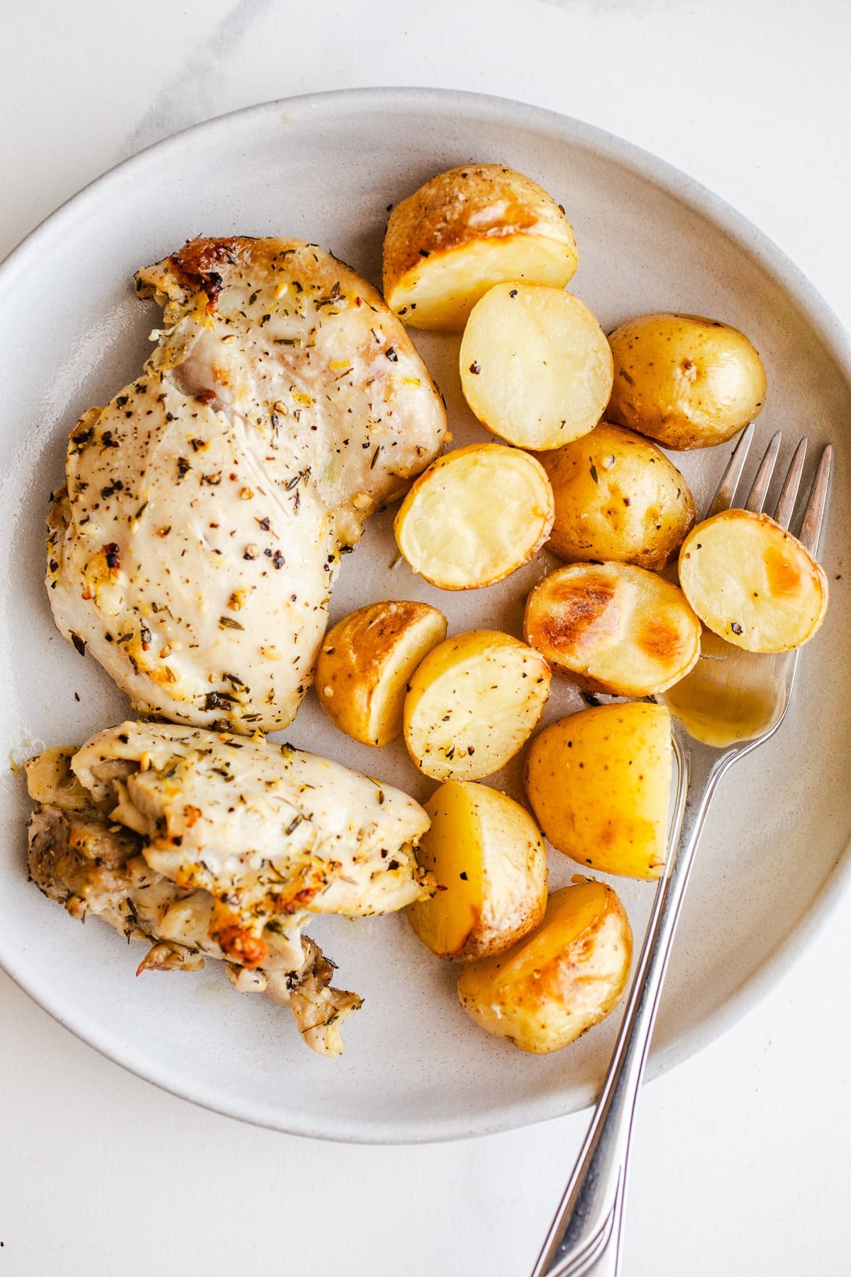 Chicken thighs and potatoes on a plate. 