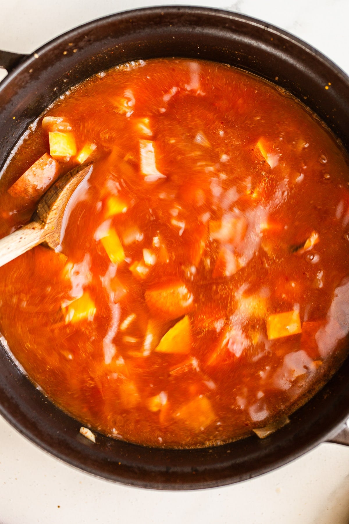 Broth being stirred in a large pot.
