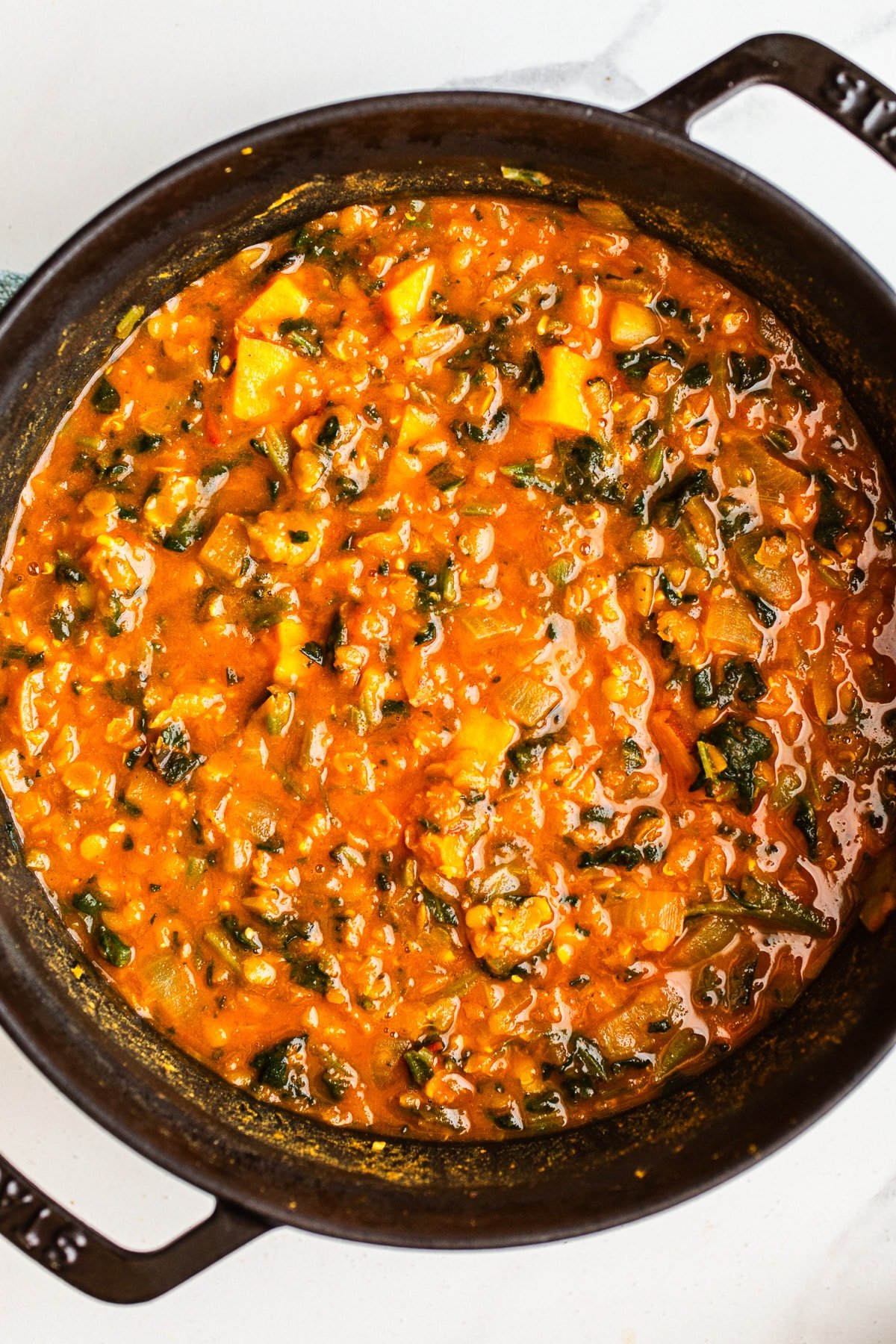 Red lentil soup with vegetables in a pot.