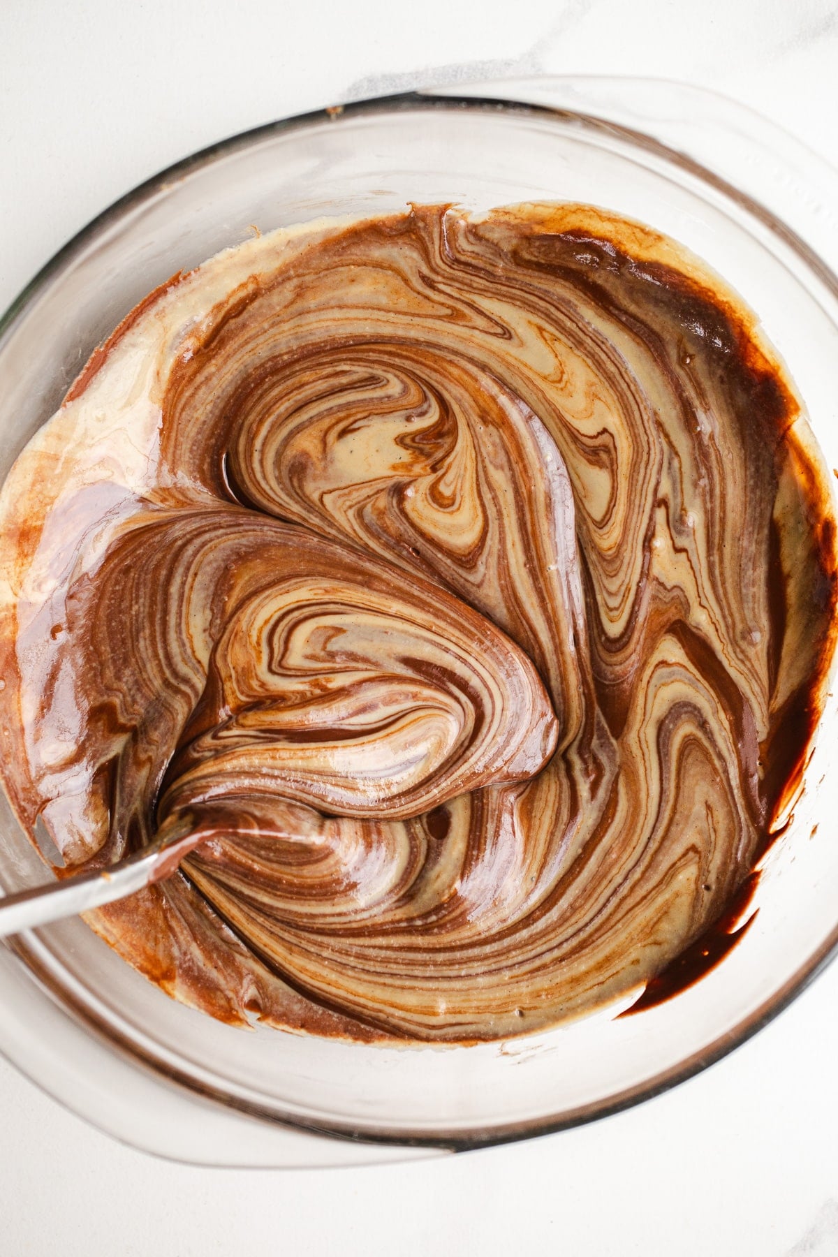 Melted chocolate and tahini in a glass bowl.
