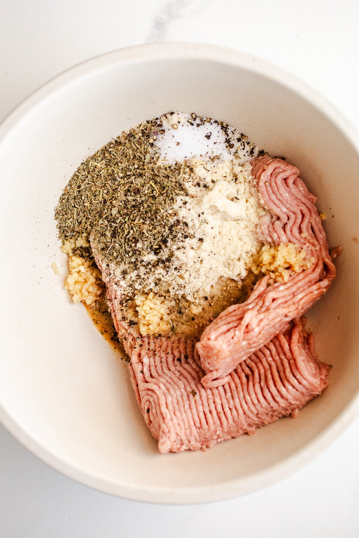 Ground turkey and seasonings in a mixing bowl.