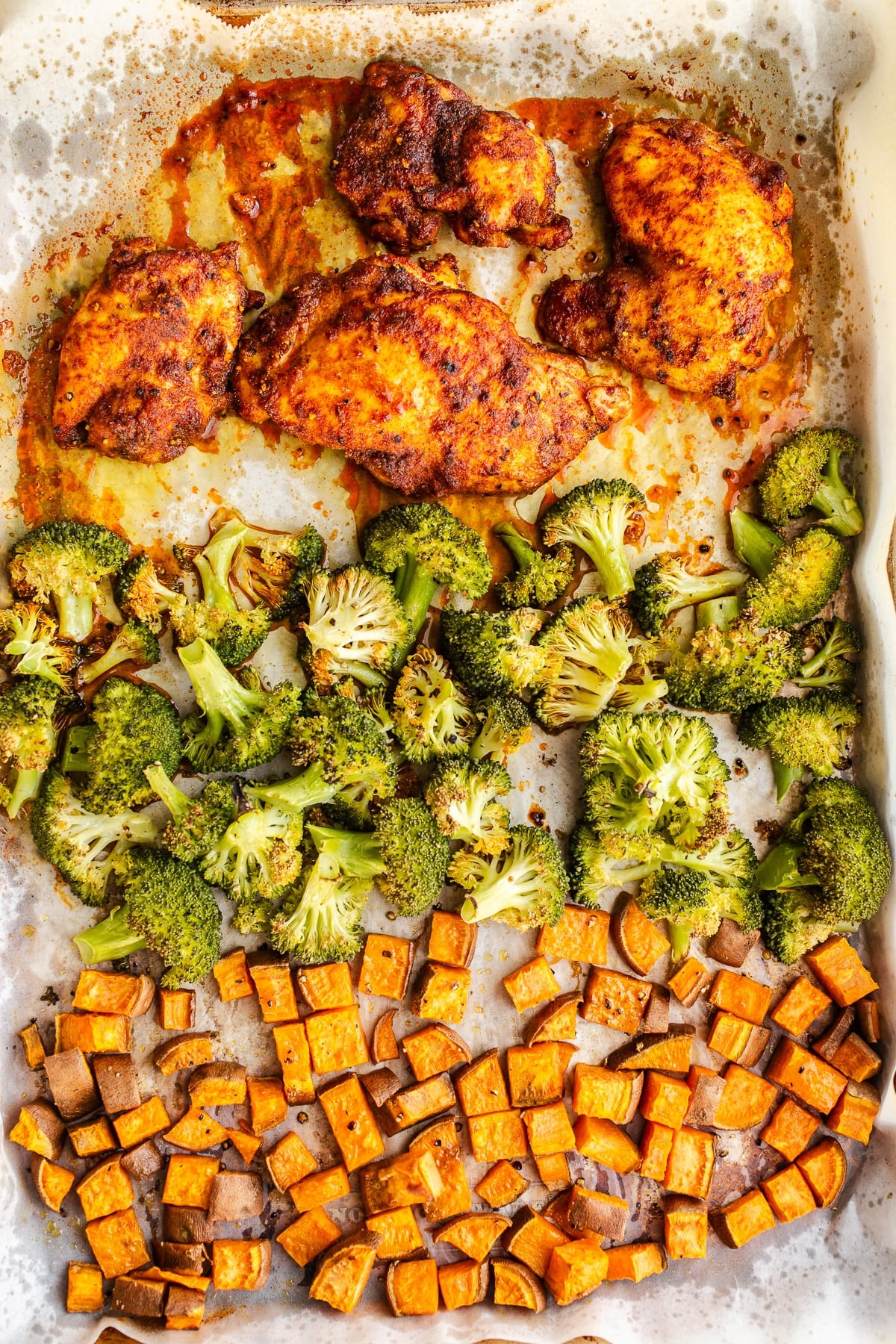 Baked chicken and vegetables on a sheet pan.