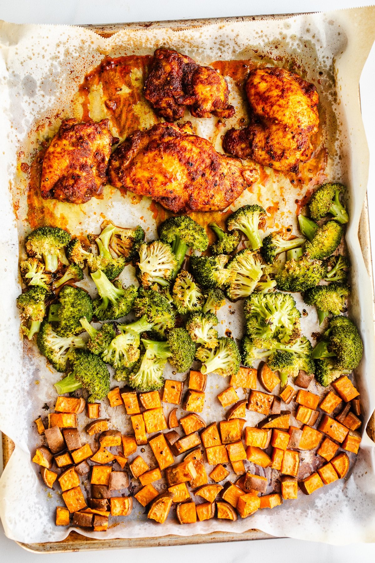 Chicken, broccoli, and sweet potatoes on a sheet pan.
