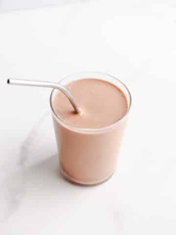 A chocolate smoothie with a metal straw.